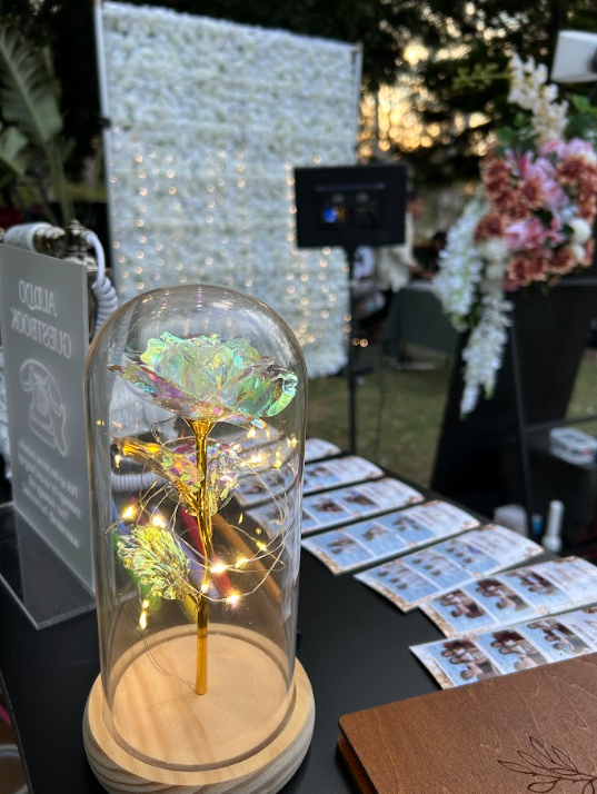 Mirror photobooth event display with guest prints and floral styling