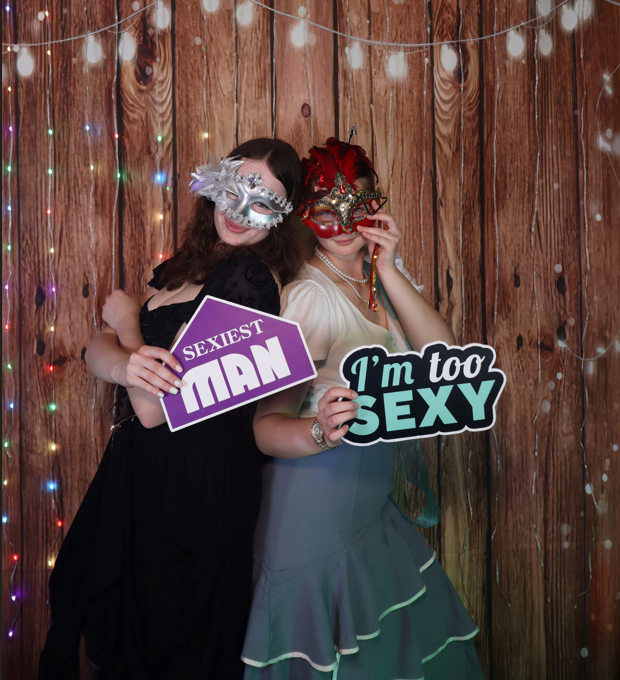 Mirror photobooth guests posing with masks and signs